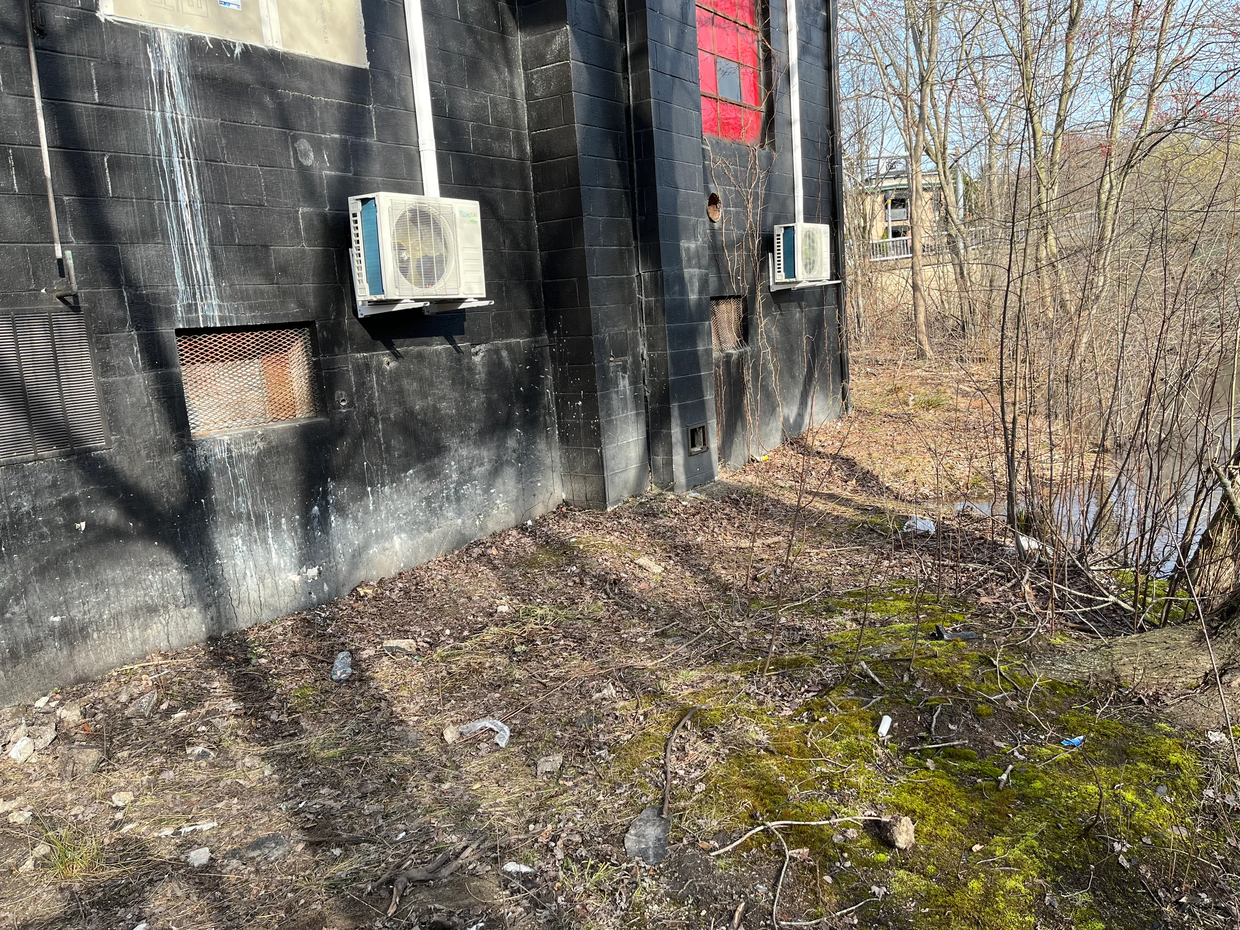 Two white mini-split HVAC condenser units mounted on dark exterior wall